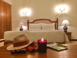 a bed with a hat and a candle on a table at Samsara in Galle +26 photos