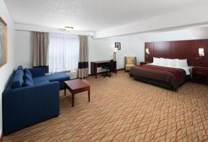 a hotel room with a bed and a couch at Red Lion Inn & Suites Auburn in Auburn