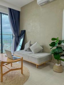 a living room with a couch and a table with a laptop at An homestay, apartment Nera Huế in Thôn Văn Dương