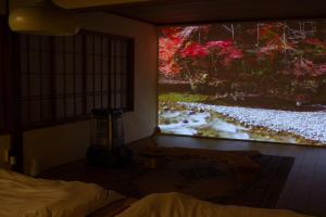 a bedroom with a large painting on the wall at TEIEN stay sauna in Ōtani