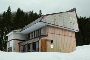 a house with a garage in the snow at TEIEN stay sauna in Ōtani