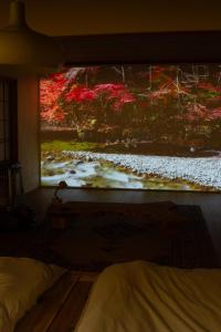 a bedroom with a large painting on the wall at TEIEN stay sauna in Ōtani