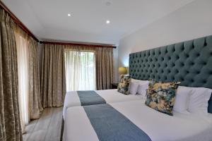 ロードポートにあるBlack Eagle Hotel & Spaの大きなベッドと大きな窓のある寝室