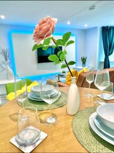 a table with glasses and plates and a rose on it at House Andiamo Portsmouth, Centrally located, Sleeps 3 in Portsmouth