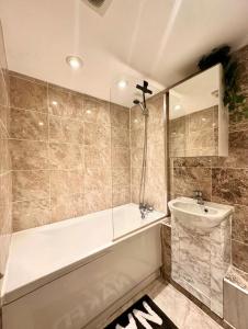 a bathroom with a bath tub and a sink at House Andiamo Portsmouth, Centrally located, Sleeps 3 in Portsmouth