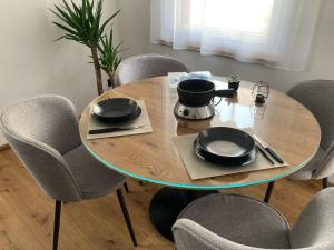 a wooden table with chairs and a table with plates and pans at Casa Suvita , Alpine Luxury Apartment Surselva in Flond