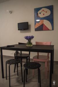 stół jadalny z krzesłami i wazon kwiatów w obiekcie B&B Mar del Plata w mieście Porto Recanati
