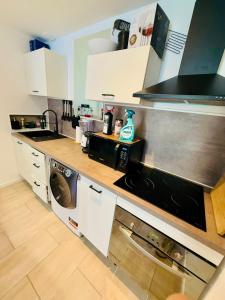 a kitchen with white cabinets and a counter top at Maison au coeur du Sidobre in Saint-Salvy-de-la-Balme