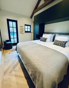 a bedroom with a large bed in a room at Landhuisje ter Heide - charming cottage with hottub in De Moer