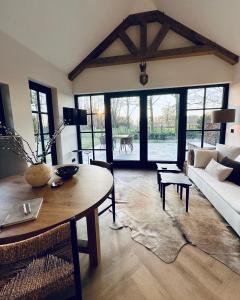 a living room with a table and a couch at Landhuisje ter Heide - charming cottage with hottub in De Moer