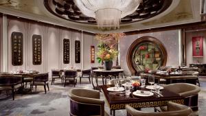上海上海外滩瑞吉酒店的有桌椅和枝形吊灯的餐厅