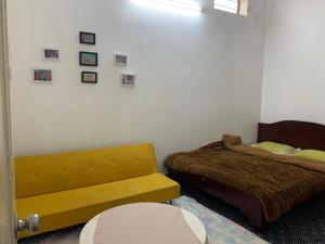 a bedroom with two beds and a yellow bench at Ngọc Am homestay in Hanoi