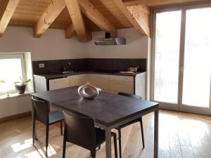 a kitchen with a black table and chairs at R&B La Calzoleria in Mori