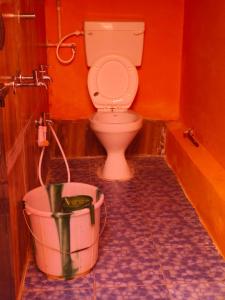 a bathroom with a toilet and a bucket at farmer homestay yercaud in Yercaud +13 photos