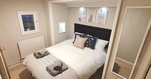 a bedroom with a bed with white sheets and pillows at Reigate - Cosy 1 Bed apartment in Reigate