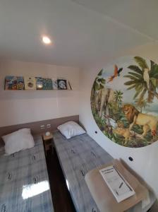 BoofzheimにあるBungalow Boofzheim Europa Parkのベッドが2つあり、壁に絵が飾られている部屋 +17枚の写真