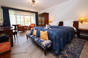 a bedroom with a bed and a couch in it at Landhuishotel De Bloemenbeek in De Lutte