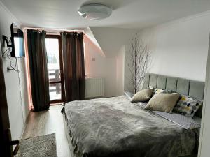 a bedroom with a large bed and a window at Casa Albă in Vatra Moldoviţei