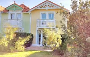 ein Haus mit einem Balkon auf der Vorderseite in der Unterkunft "ENTRE GREENS ET VAGUES" Maison de vacances, cœur d'un golf, résidence privée, accès piscines gratuit in Talmont