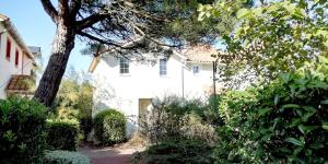 ein weißes Haus mit einem Baum davor in der Unterkunft "ENTRE GREENS ET VAGUES" Maison de vacances, cœur d'un golf, résidence privée, accès piscines gratuit in Talmont + 37 Fotos