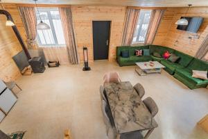 un soggiorno con un divano verde e un tavolo di Mountain house in Mestia a Mestia