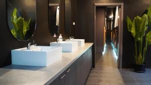 a bathroom with two sinks and two mirrors at Hood Pattaya in Pattaya +46 photos