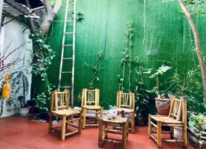 a room with four chairs and a green wall at Ngọc Am homestay in Hanoi