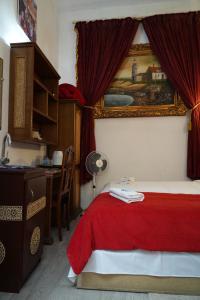 una camera con letto con coperta rossa e scrivania di Dar Essaki 1886 a Tangeri