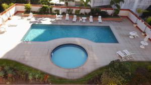 an overhead view of a swimming pool with chairs and tables at Via Park Flat PARAÍSO in Campos dos Goytacazes