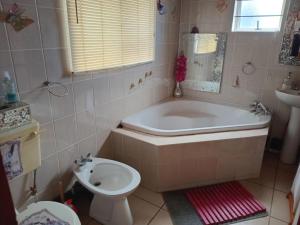 a bathroom with a tub and a toilet and a sink at Lion's Cave 3 in Mossel Bay