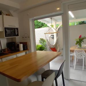 a kitchen and dining room with a table and chairs at RESIDENCE BEL COLIBRI la Caravelle Hibiscus & SPA in Sainte-Anne