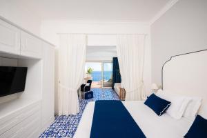a hotel room with a bed and a view of the ocean at Grand Hotel Tritone in Praiano
