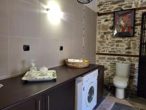 a bathroom with a washing machine and a toilet at Rustic House in Eleftheroúpolis