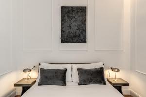 a bedroom with a white bed with two lamps at ArtPartment in Naples +53 photos