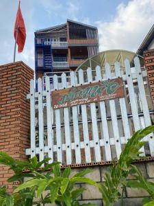 a white picket fence in front of a building at Homestay Nhà Mộc in Da Lat