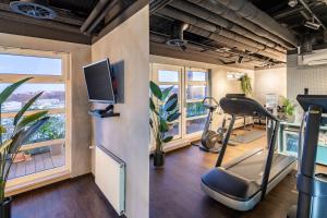 a gym with a treadmill and a flat screen tv at NH Hamburg Altona in Hamburg