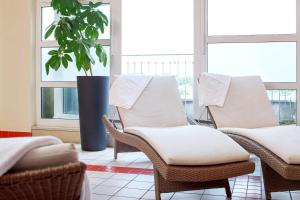 a room with three chairs and a potted plant at NH Hamburg Altona in Hamburg