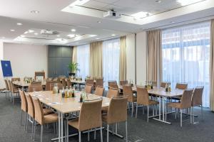 a conference room with long tables and chairs at NH Hamburg Altona in Hamburg