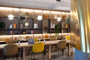 a dining room with a table with chairs and a laptop at NH Hamburg Altona in Hamburg