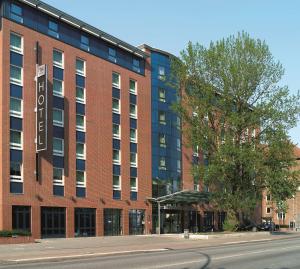 a large red brick building on a city street at NH Hamburg Altona in Hamburg