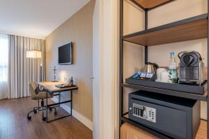 a hotel room with a desk and a room at NH Hamburg Altona in Hamburg