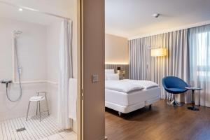 a hotel room with a bed and a shower at NH Hamburg Altona in Hamburg