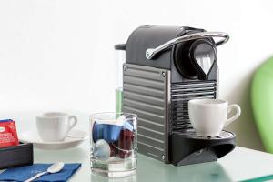 a coffee maker and a glass of water on a table at NH Hamburg Altona in Hamburg