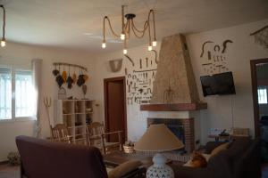 a living room with a couch and a fireplace at Casa rural de encanto en plena Serranía de Ronda in Ronda