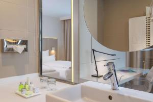 a bathroom with a sink and a mirror at NH Hamburg Altona in Hamburg