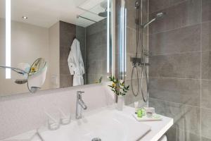 a bathroom with a sink and a shower at NH Hamburg Altona in Hamburg