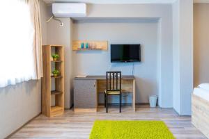 a room with a desk with a television and a chair at Tryavna Lake Hotel & SPA in Tryavna