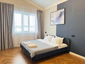 a bedroom with a bed with towels on it at Гостевой дом Burabay Grand Village in Borovoye