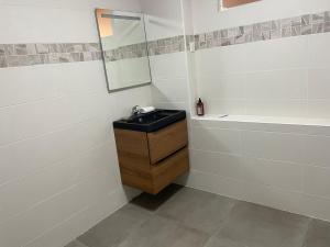 a bathroom with a black sink and a mirror at Appartement cozy et confort avec JACUZZI proche CDG Parc Astérix Chantilly Paris in Fosses +7 photos