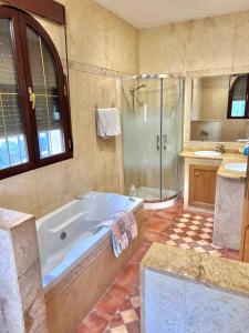 a large bathroom with a tub and a shower at El Carmen in Córdoba